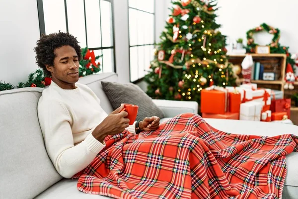 Young African American Man Sitting Sofa Drinking Coffee Christmas Tree — Stock Photo, Image