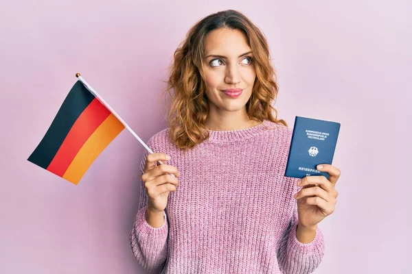 Joven Mujer Caucásica Sosteniendo Bandera Alemania Pasaporte Sonriendo Mirando Costado —  Fotos de Stock