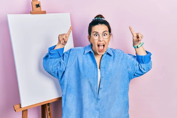 Young Hispanic Woman Standing Painter Easel Stand Smiling Amazed Surprised — Stock Photo, Image