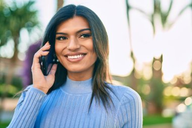 Kasabadaki genç İspanyol kadın telefonda konuşuyor.