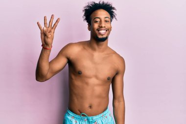 Sakallı, mayo giymiş, dört numaralı parmaklarıyla işaret eden, kendinden emin ve mutlu genç Afro-Amerikalı bir adam.. 