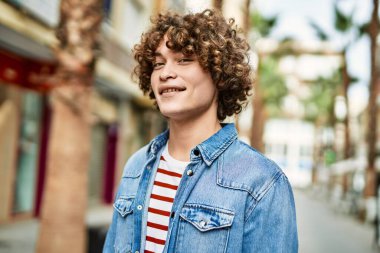 Genç İspanyol adam şehre gülümsüyor.