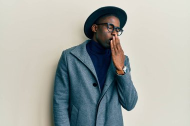 Zarif tarzda giyinen genç Afro-Amerikalı adam ağzını eliyle kapatmaktan sıkıldı. Huzursuz ve uykulu.. 
