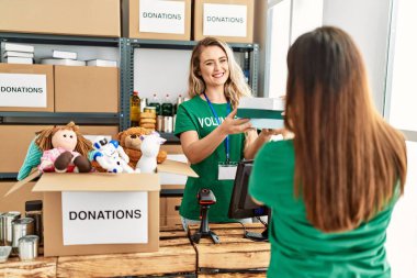 Genç gönüllü kız yardım merkezinde kadına yardım ediyor..