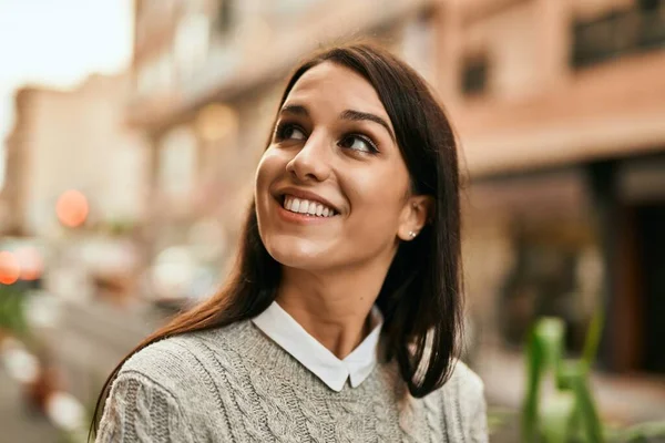 若いヒスパニック系の女性が幸せそうに街に立って笑っている — ストック写真
