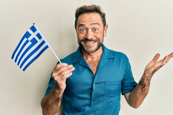 Homem Meia Idade Segurando Bandeira Grega Celebrando Realização Com Sorriso — Fotografia de Stock