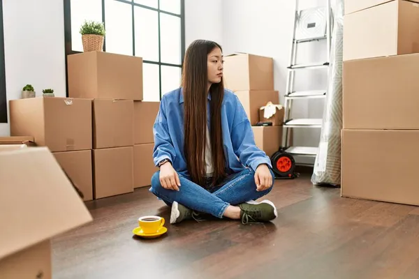 Menina Chinesa Jovem Sentado Chão Nova Casa Olhando Para Lado — Fotografia de Stock