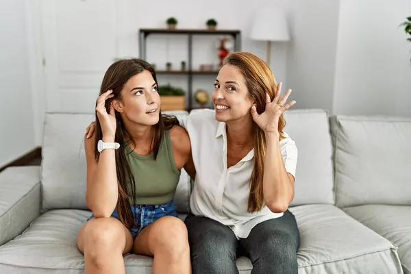 Mãe Filha Juntas Sentadas Sofá Casa Sorrindo Com Mão Sobre — Fotografia de Stock