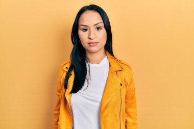 Burnunda piercing olan, sarı deri ceket giyen, yüzünde ciddi bir ifadeyle rahatlamış güzel İspanyol bir kadın. Basit ve doğal bir şekilde kameraya bakıyorsun.. 