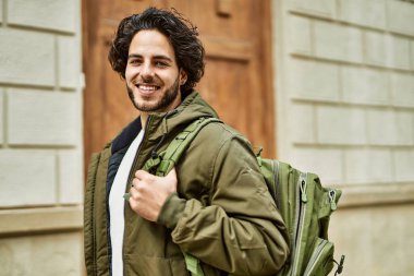 Yakışıklı İspanyol adam şehre gülümsüyor.