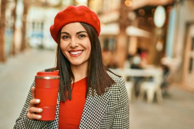 Genç İspanyol kadın gülümsüyor. Mutlu bir şekilde içiyor. Şehirde kahve içiyor..