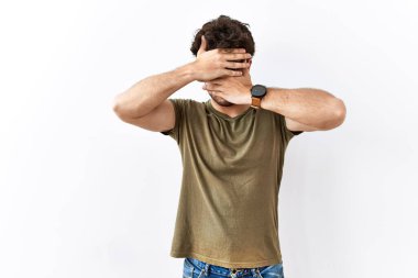 İzole edilmiş beyaz arka planda duran İspanyol adam gözlerini ve ağzını elleriyle kapatıyor, şaşırmış ve şok olmuş. duygu gizleme 