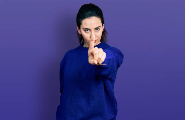 Genç İspanyol kadın gündelik giysiler giyip parmağını kaldırmış ve kızgın bir ifadeyle işaret ediyor. Hiç hareket göstermiyor. 