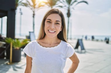 Sokakta kendinden emin gülümseyen genç İspanyol kadın.