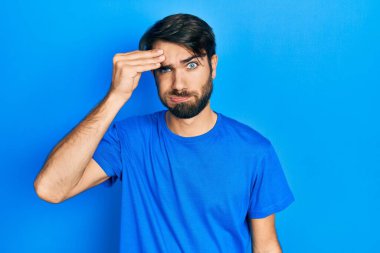 Gündelik kıyafetler giyen genç İspanyol adam, alında bir sorun olduğu için endişeli ve stresli, gergin ve kriz için endişeli. 