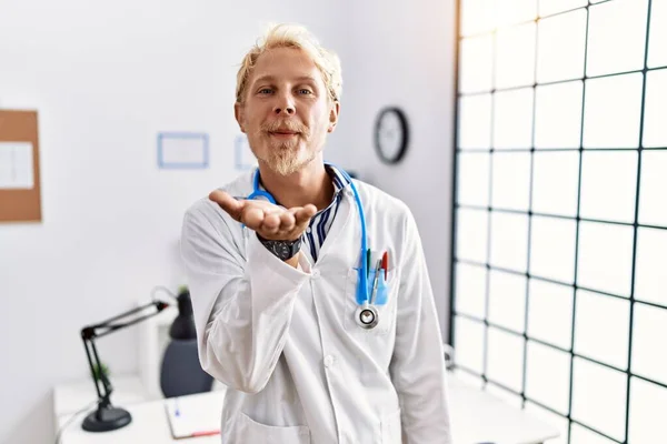 Klinikte Doktor Üniforması Giyen Steteskop Takmış Genç Sarışın Bir Adam — Stok fotoğraf