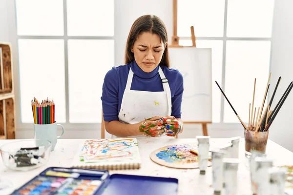 年轻的黑发女子在艺术工作室里手绘手绘在肚子上 因为恶心 痛苦的疾病感觉不舒服 疼痛的概念 — 图库照片