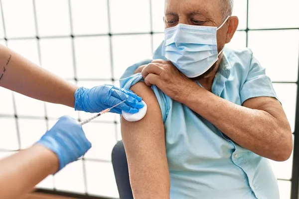 安全性のママを持つシニア男性は Covid 19免疫ワクチン 看護師注射予防ワクチンで予防接種を受けます — ストック写真
