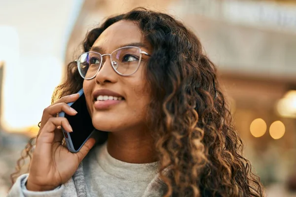 Young latin woman smiling happy talking on the smartphone at the city.