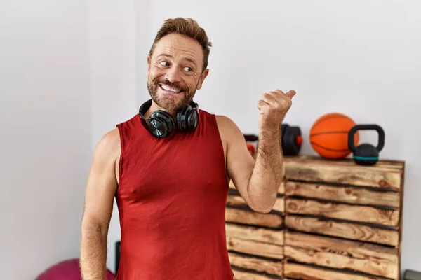 Μεσήλικας Άνδρας Που Φοράει Αθλητικά Και Ακουστικά Στο Γυμναστήριο Χαμογελώντας — Φωτογραφία Αρχείου