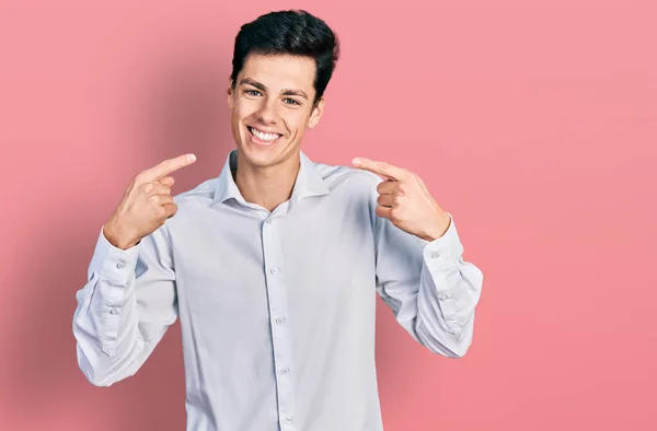 若いヒスパニック系のビジネスマンのビジネス服を着て笑顔を見せ 指の歯と口で指差す 歯の健康の概念 — ストック写真
