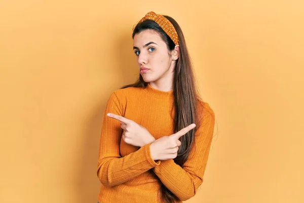 Young Brunette Teenager Wearing Casual Yellow Sweater Pointing Both Sides — Stock Photo, Image