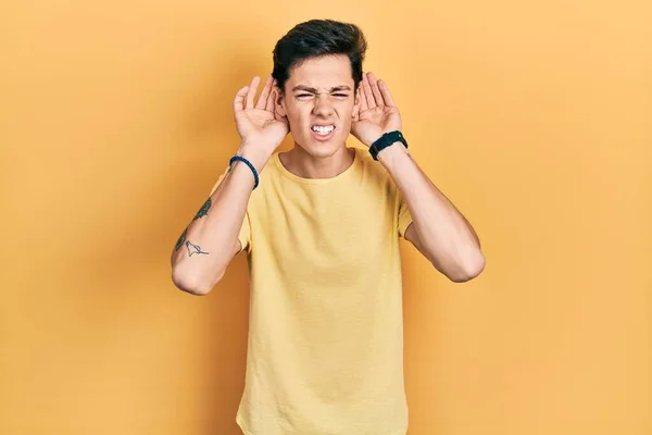 Νεαρός Ισπανός Που Φοράει Απλό Κίτρινο Μπλουζάκι Προσπαθώντας Ακούσει Και — Φωτογραφία Αρχείου