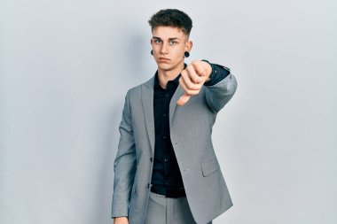 Kulakları genişlemiş, iş ceketi giymiş, mutsuz, kızgın, reddedilmiş ve olumsuz jestler yapan beyaz bir genç. kötü ifade. 