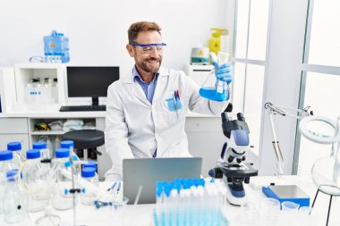 Orta yaşlı, labaratuarda çalışan bilim adamı üniforması giyen bir İspanyol.