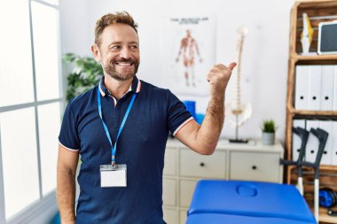 Orta yaşlı fizyoterapist. Ağrı kesici kliniğinde çalışıyor. Gülümsüyor, gülümsüyor.. 