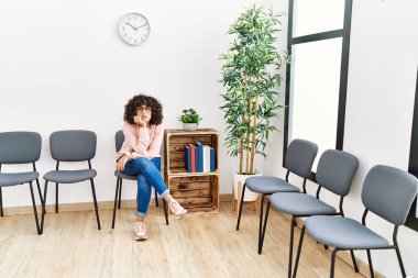 Bekleme odasında oturan Ortadoğu 'lu çaresiz genç kadın.