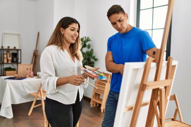 Öğrenci ve öğretmen resim yaparken gülümsüyor..