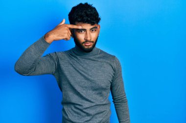 Balıkçı yaka kazak giyen sakallı bir Arap alnında sivilceden mutsuz siyah nokta enfeksiyonu olduğunu söylüyor. sivilce ve deri problemi 