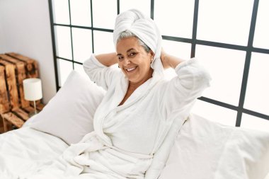 Orta yaşlı, kır saçlı, mutlu gülümseyen bir kadın yatak odasında yatıyordu..