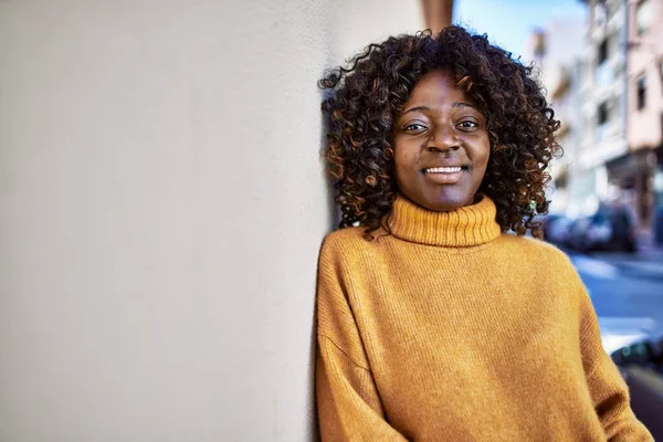 Afrykańska Amerykanka Uśmiecha Się Pewnie Opierając Się Ścianie Ulicy — Zdjęcie stockowe