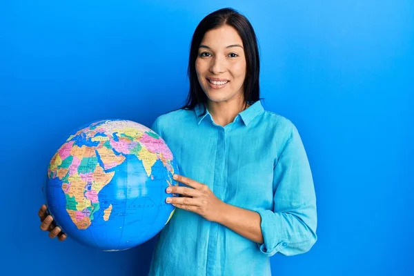 Mujer Latina Joven Sosteniendo Gran Bola Del Mundo Mirando Positiva — Foto de Stock