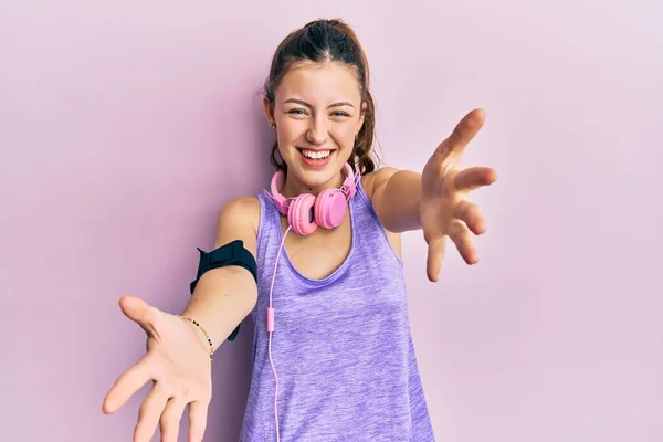 Jonge Brunette Vrouw Draagt Sportkleding Koptelefoon Kijkend Naar Camera Glimlachend — Stockfoto