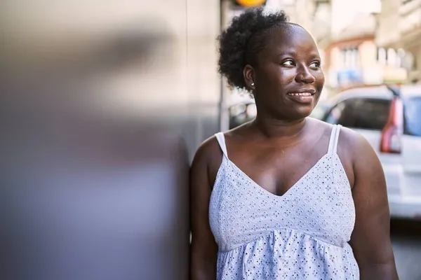 若いアフリカ系アメリカ人の女性が幸せそうに街に立っている — ストック写真