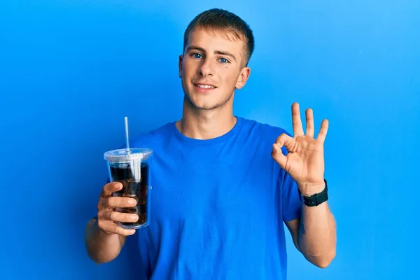 Homem Caucasiano Jovem Bebendo Copo Bebida Refrigerante Fazendo Sinal Com — Fotografia de Stock
