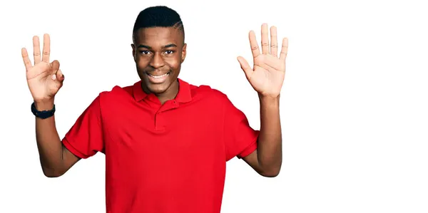 年轻的非洲裔美国人 身穿休闲红色T恤 手指点点八号 面带微笑 自信而快乐 — 图库照片