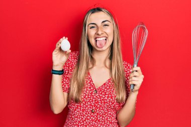 Yumurta tutan güzel İspanyol kadın ve fırıncı fırça çırpıcı komik bir ifadeyle dilini dışarı çıkarıyor.. 