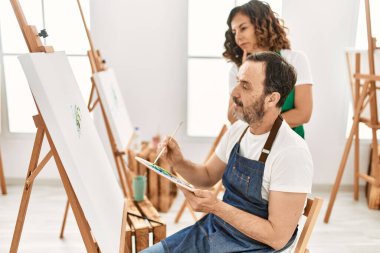 Sanat okulunda resim yapan orta yaşlı bir öğrenci ve öğretmen..