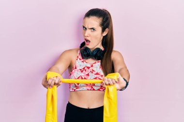 Genç esmer kız kollarına direnç gösterip şok olmuş kollarında lastikle kuşkucu, alaycı ve ağzı açık bir şekilde şaşırmış görünüyor. 