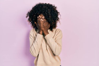 Genç Afro-Amerikalı kadın, ağlarken suratını ellerle kapatan sıradan kıyafetler giyiyor. depresyon kavramı. 