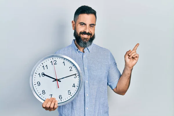 Jeune Homme Hispanique Tenant Une Grande Horloge Souriant Heureux Pointant — Photo