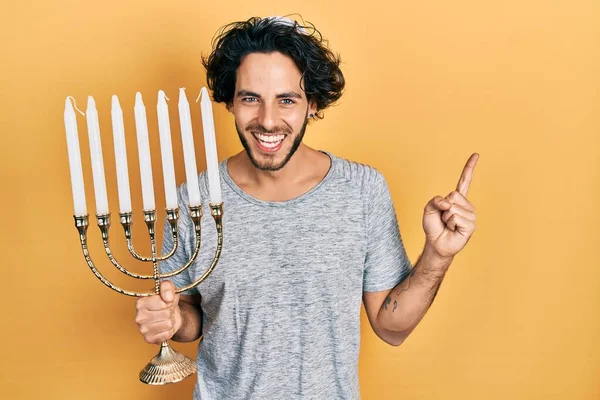 Hombre Hispano Guapo Sosteniendo Menorah Hanukkah Vela Judía Sonriendo Feliz — Foto de Stock