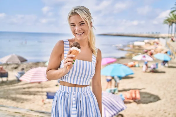 若いですブロンド女の子食べるアイスクリームスタンディングにザビーチ — ストック写真