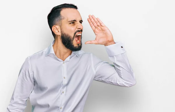 髭を生やした青年がビジネスシャツを着て大声で叫びながら口の上で手で横に叫んでいた コミュニケーションの概念 — ストック写真