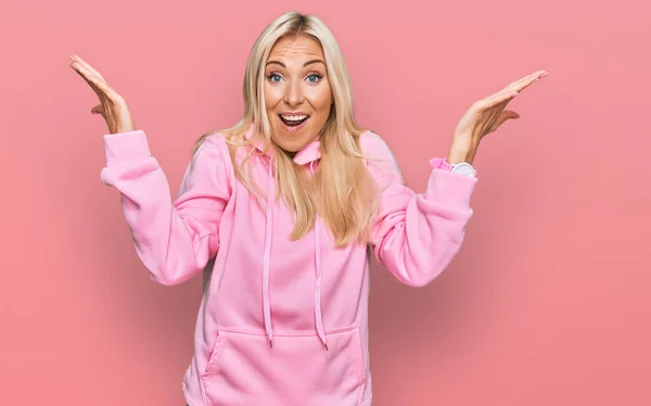 Ung Blond Kvinna Bär Casual Sweatshirt Firar Galen Och Förvånad — Stockfoto