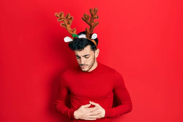 Mladý Hispánec Nosící Roztomilé Vánoční Rohy Soby Rukou Břiše Protože — Stock fotografie